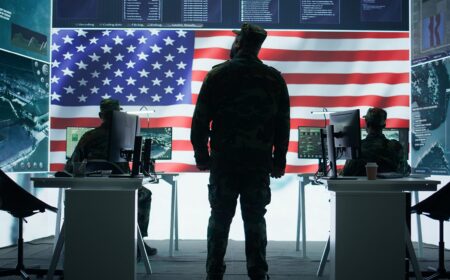 US military officer supervising threat detection activity in high tech office, examining top secret data on big screen. American army soldiers managing hybrid war, cyber attack prevention. Camera B.